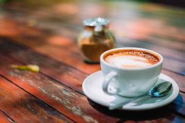Sıcak kahve latte kapuçino sarmal köpük kahve dükkanı Cafe vintage renk tonu filtre arka plan ile ahşap masa üzerinde. Metniniz için kopya alanı ile. Renk tonu efekti