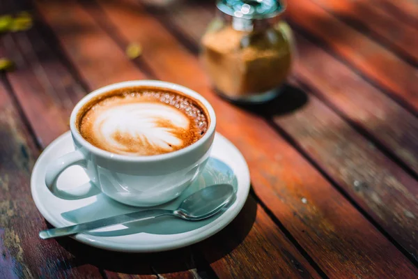 Sıcak kahve latte kapuçino sarmal köpük kahve dükkanı Cafe vintage renk tonu filtre arka plan ile ahşap masa üzerinde. Metniniz için kopya alanı ile. Renk tonu efekti