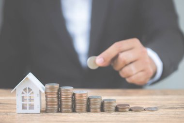 Para madeni para yığınının adım büyüme modeli beyaz ev ahşap masa üzerinde büyüyor. Gayrimenkul yatırım ve house mortgage mali kavramı, eve korumak, sigorta. Metniniz için kopya alanı ile.