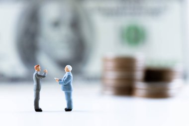 Minyatür insanlar, para destesiyle dolar banknotunun üzerinde duran iş adamı. Risk yönetimi işletmeleri finans ve yatırım yüzdesi faiz oranları kavramının yönetimi. kopyalama alanı ile.