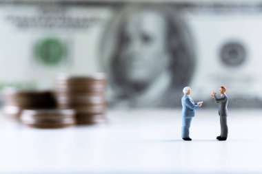 Minyatür insanlar, para destesiyle dolar banknotunun üzerinde duran iş adamı. Risk yönetimi işletmeleri finans ve yatırım yüzdesi faiz oranları kavramının yönetimi. kopyalama alanı ile.