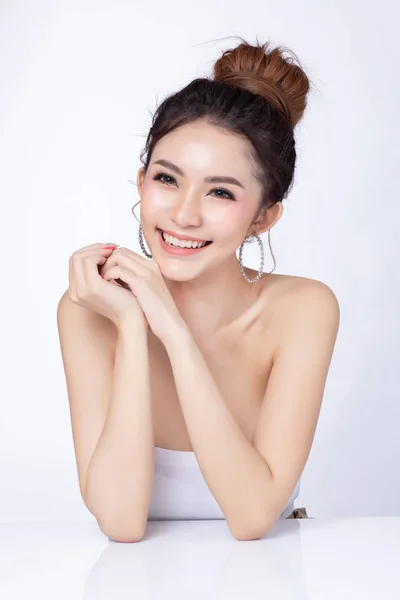 Retrato de mulher asiática atraente sentado sorrindo no fundo branco. Mulher de pele saudável maquiagem natural beleza rosto conceito. Usando como seu produto . — Fotografia de Stock