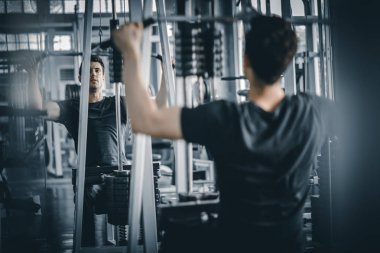 Portre yakışıklı, beyaz, sağlıklı bir genç adam spor salonunda egzersiz yapıyor. Güzellik, vücut incelticiliği. Özgürlük mutlu ve yaşam tarzı sağlık hizmetleri kavramını gevşetin.