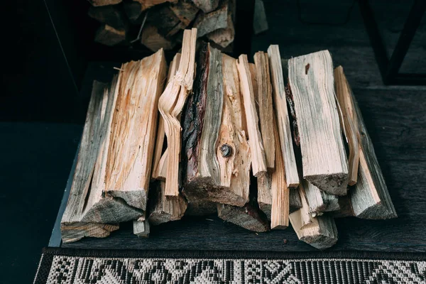 Koš s palivové dřevo na dřevěné pozadí — Stock fotografie