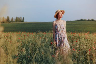Genç nazik kadın günbatımı ışık demeti rahatlatıcı. Tam uzunlukta portre çiçek alanı