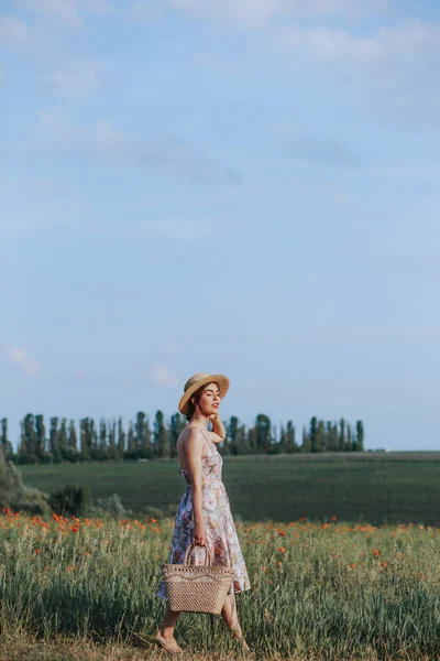 夕暮れ時の背景に花畑を歩いて若い女性 コピー領域の水平方向のビュー — ストック写真