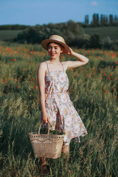 Arka plan üzerinde gün batımında çiçek alan üzerinde yürüyen genç kadın. Kopya alanı ile yatay görünüm