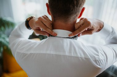 Damat sabah hazırlığı, yakışıklı damat giyiniyor ve düğün için hazırlanıyor, koyu mavi takım elbise içinde..