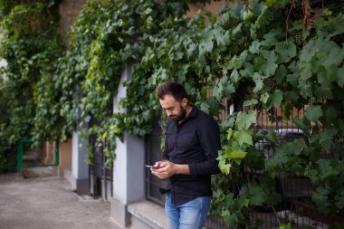 Harika bir genç adam bir akıllı telefon kullanır. Sakallı hippi cep telefonuna bir mesaj yazıyor. Kopya alanı.