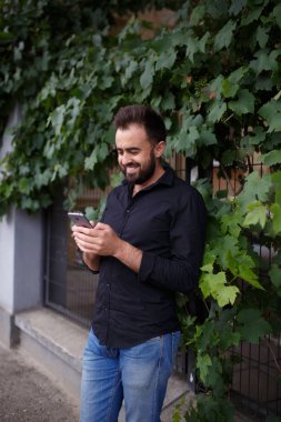 Harika bir genç adam bir akıllı telefon kullanır. Sakallı hippi cep telefonuna bir mesaj yazıyor. Kopya alanı.