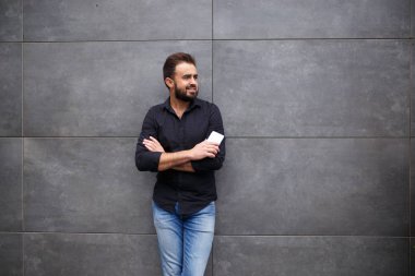 Bir sakallı bir adamın çıkıp telefonla konuşuyor