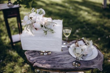 Beyaz düğün pastası pions ile süslüdür