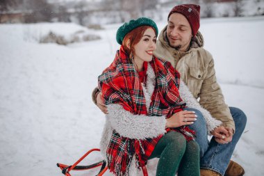 Young couple hugging and kissing in the forest in winter. Couple on valentine's day in winter park