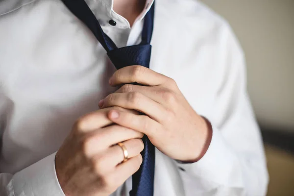 Concetto di persone, affari, moda e abbigliamento: primo piano dell'uomo in camicia che si veste e regola la cravatta sul collo a casa . — Foto Stock