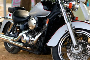 Beyaz motosikletin yanında duran klasik siyah motosiklet güneş ışığının altında. Yan görünüm