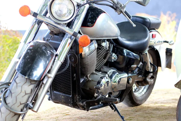 Ročník černá motocykl stojí v blízkosti bílé motorce v paprscích slunečního světla. Boční pohled Stock Fotografie