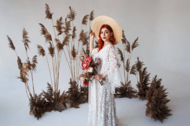 Düğün içeriği - Yakın Portre genç güzel kızıl saçlı kız süslemeleri ile beyaz bir arka plan üzerinde bir stüdyoda bir şapka. Kopyalama alanı