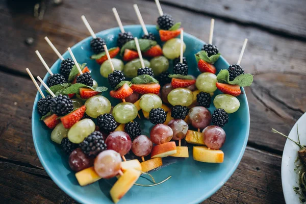 Petits hamburgers avec viande, salades fromage et tomates dans une assiette en bois pendant la soirée barbecue d'été en plein air . — Photo