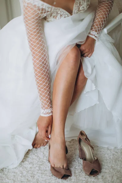 A bride to put on her wedding shoes. Beautiful female feet closeup.