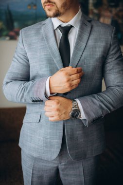 İnsanlar, iş, moda ve giysi konsepti - Erkeğin giyinme ve evde düğme bağlama konsepti.