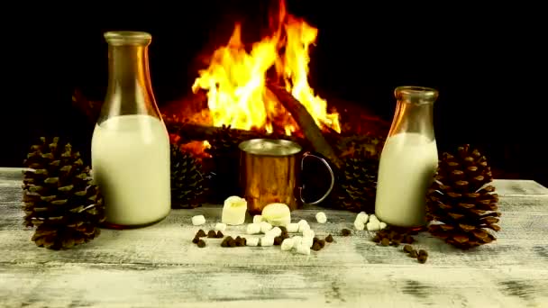 Chocolate caliente frente a un fuego con leche y conos de pino. Imágenes de stock libres de derechos