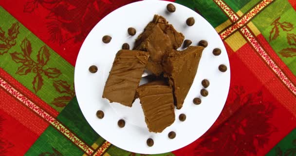 Fudge rotante su un piatto bianco con sfondo a tema natalizio. Video Stock Royalty Free