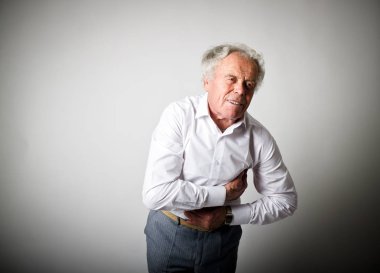 Kalp krizi. Yaşlı adam kalp krizi geçirerek acı göğüs ağrısı ile.