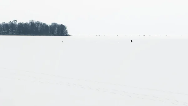 Kış Balıkçılık buzlu göl, doğal arka kenarında. Minimalist tarzı doğal havadan görünümü. Siyah ve beyaz tonlarda minimalist fotoğraf.