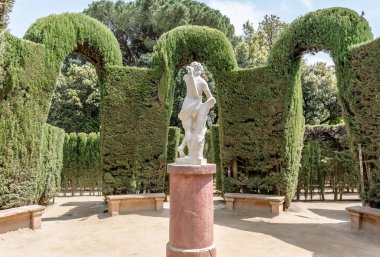 Barcelona, İspanya - 10 Mayıs 2018: Eros heykeli, âşık labirenti Park Horta ortasına Yunan tanrısı. Arkadan vurdu karşı üç selvi girişi, mermer heykel biçilmiş kaftan bir kemer