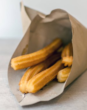 Geleneksel İspanyol tatlı churro kahverengi kağıt koni. Bir churro dayalı kızarmış hamur pasta çerezim. Bir churrera - yıldız şeklinde meme ile bir araç üzerinden borulu nedeniyle, yüzey sırt.