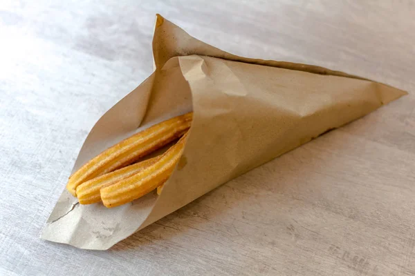 Geleneksel İspanyol tatlı churro kahverengi kağıt koni. Bir churro dayalı kızarmış hamur pasta çerezim. Bir churrera - yıldız şeklinde meme ile bir araç üzerinden borulu nedeniyle, yüzey sırt.