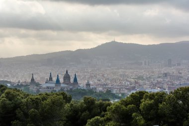 Barcelona city için ön planda Palau Nacional (National Palace) Rönesans kubbe ile bulutlu akşam Montjuic tepeden görüntüleyin. Barcelona akşam manzarası bulutlu gökyüzü altında.
