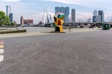 Rotterdam, Hollanda - 22 Mayıs 2018: Erasmus Köprüsü, kuğu, gökdelenler, arka plan ve renkli heykel 'Maraton' denilen Kop van Zuid bölgesinde ön planda takma.