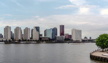 Rotterdam, Hollanda - 22 Mayıs 2018: Nieuwe Maas nehri üzerinde uzun boylu etkileyici gökdelenler ve gemi ile modern yenilikçi şehir merkezine görünüm.