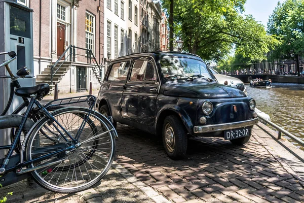アムステルダムの運河の つに駐機しているアムステルダム オランダ 2018 黒古いさびたイタリア小型車の前面フィアット 500 Giardiniera — ストック写真