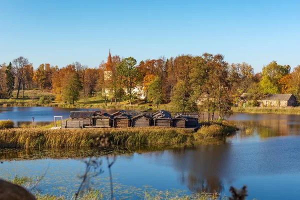 9-10 yüzyıla otantik kopyası konut sitesi Latgallians - ahşap lake Kalesi - Araisi Arkeoloji Müzesi Parkı, Letonya arka planda lutheran Kilisesi ile güçlendirilmiş.