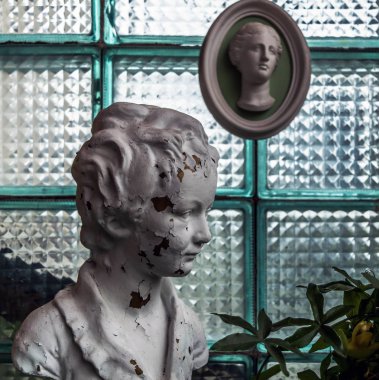 Kırık beyaz baş kalıplama antik alçı kafayla cam blok duvara heykel. Vintage kavramı.