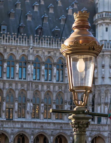 Vintage street lamp with the Gothic  Brussels Town Hall in the background on the famous Grand Place in Brussels, Belgium.