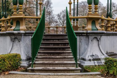 Stairs to the picturesque kiosk in Koningin Astridpark (Park of the Queen Astrid) in Bruges, Belgium. Surrounding trees and bushes make it a somewhat secluded place. clipart