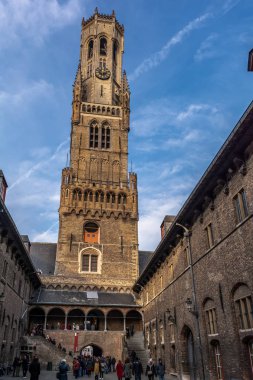 Bruges, Belçika - 15 Aralık 2018: Şehrin en ünlü simgesi olan ortaçağ çan kulesi Bruges'in 83 metre yüksekliğindeki Çan Kulesi'ne tırmanmak için insanlar sırada bekliyor.