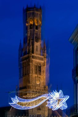Önünde Noel dekorasyonu ile Bruges Belfry soyut görüntü. Kasıtlı soyut hareket bulanıklığı efekti.