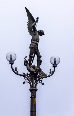 Gent, Belçika - 16 Aralık 2018: Aziz Michael Köprüsü'ndeki bir sokak lambasının tepesinde kanatlı Aziz Michael heykeli. Elinde bir kılıç ile St Michael bronz heykeli ile güzel gotik fener.