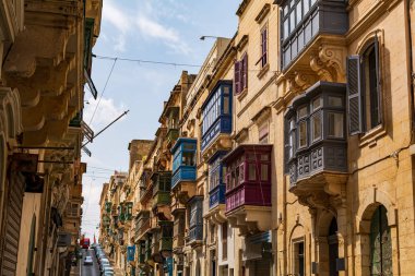 Malta 'nın Valletta kentinde yaz günü geleneksel çok renkli ahşap balkonlu ev cephesi. Otantik Malta şehir sahnesi.