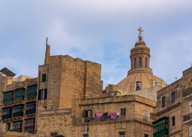 Valletta 'nın ünlü Carmelite Kilisesi' nin kubbesi. Ön plandaki konutun balkonunda çamaşırları kurutuluyor. Valletta şehir manzarası.