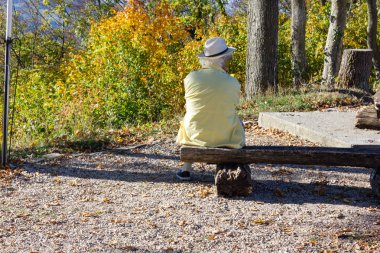 Komuta sizde Güney Almanya'da sonbahar sezonu dağın tepesinde, bankta oturmuş.