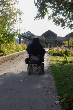 komuta sizde bir güneşli üzerinde motor bir tekerlekli sandalye ile şehir parkı ağaca sıcak ışık parlayan akşam düşmek