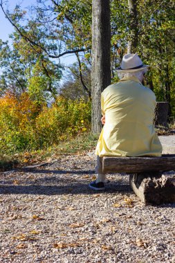 Komuta sizde Güney Almanya'da sonbahar sezonu dağın tepesinde, bankta oturmuş.