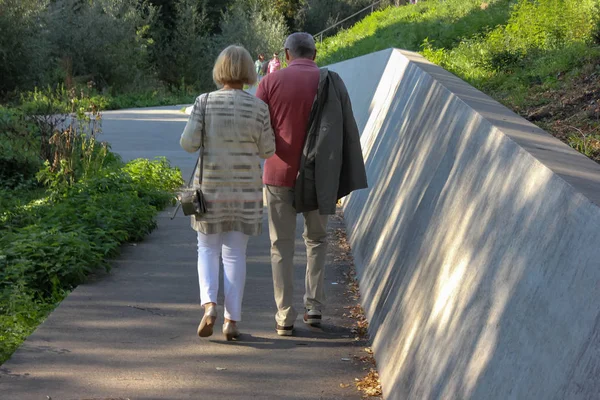 senior couple walk in park at fall evening in south germany
