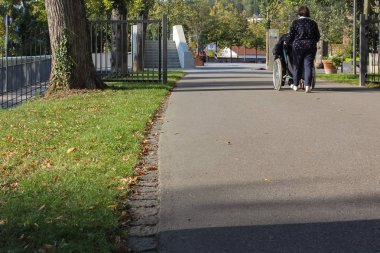 komuta sizde sonbahar akşam şehir parkında Güney Almanya tekerlekli sandalyede bayanla