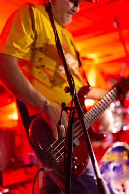 Arka plan üzerinde lambaların güçlü renkli ışık ile sahnede gitar çalan